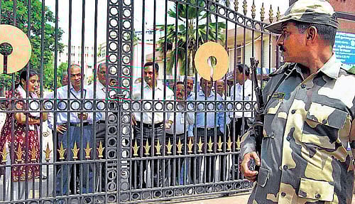 Security personnel stand guard during a protest by SBI employees supporting a united Andhra Pradesh in Hyderabad on Tuesday. PTI