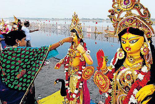A woman prays in front of an idol of Goddess Durga ready for immersion in the Yamuna river at the end of the Durga Puja festival in New Delhi on Monday. AP