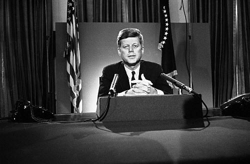 FILE - In this July 26, 1963 file photo, U.S. President John F. Kennedy sits behind microphones at his desk in Washington after finishing his radio-television broadcast to the nation on the nuclear test ban agreement initialed by negotiators in Moscow. AP photo