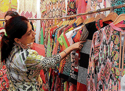 for shopaholics (Above and below) Visitors look at designer wear, chunky jewellery and trendy shoes displayed in an exhibition.