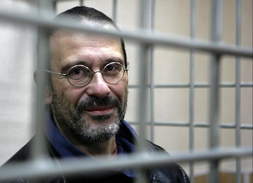 In this photo released by Greenpeace International, activist Dima Litvinov from Sweden looks from a defendants' cage at the district court, in Murmansk, Russia, Wednesday, Oct. 23, 2013. Litvinov is one of the 'Arctic 30' who are in custody charged with piracy, punishable for up to 15 years in jail, after being detained on board the Greenpeace ship Arctic Sunrise, which was seized nearly four weeks ago by Russian security forces after some activists tried to scale an offshore oil platform. AP Photo.