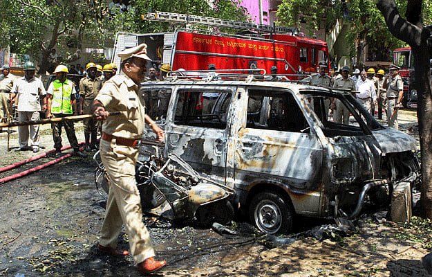 Police personnel inspect the site of the blast near the BJP office at Malleswaram in Bangalore. File PTI Image