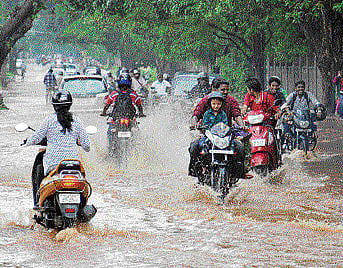 rain fury: Motorists wade through the waterlogged SJCE Road near Regional College in Mysore on Friday. dh Photo