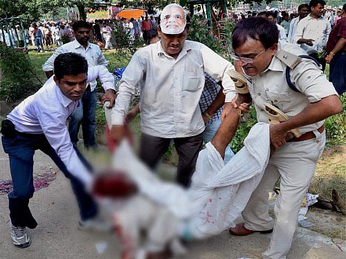 Police and locals carry the body of a vicitim after six serial bomb blasts took place at the venue of Narendra Modi's Hunkar rally in Patna on Sunday. PTI Photo