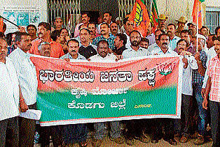 Members of BJP Krishi Morcha unit stage a protest in front of the Deputy Commissioner's office demanding the government to release additional compensation for crop loss in Madikeri on Monday. DH PHOTO