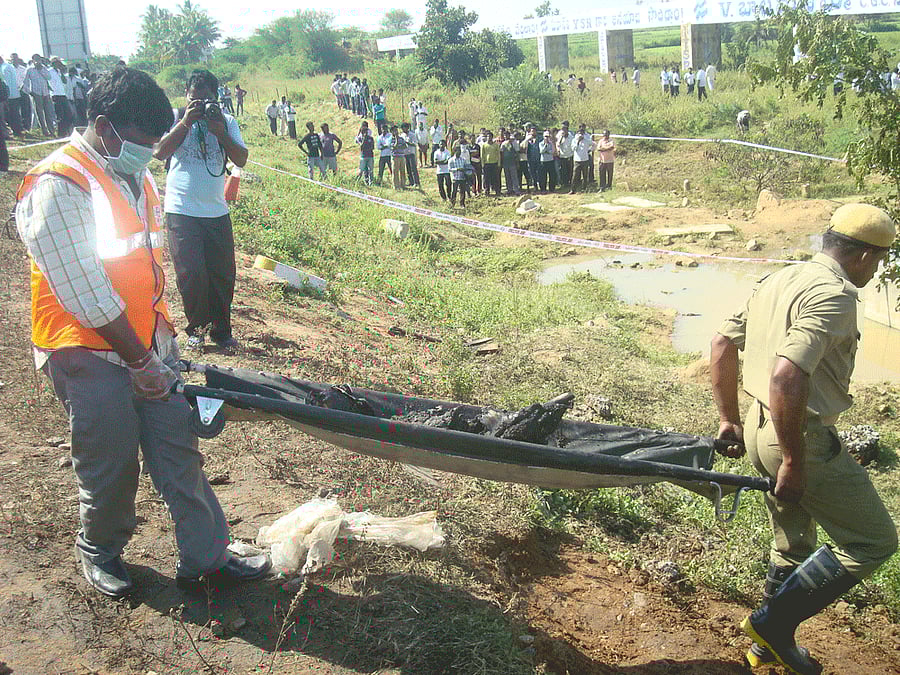 Rescue workers carry the remains of a passenger on Wednesday near Palem in Mahabubnagar. DH photo.