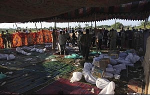 Policemen and others stand near bodies of victims killed in a bus accident at Mehabubnagar, Andhra Pradesh, Wednesday, Oct. 30, 2013. The bus crashed into a highway barrier and burst into flames Wednesday morning, killing more than 40 passengers who were locked inside the cabin, many of them burned alive in the inferno, officials said. AP Photo
