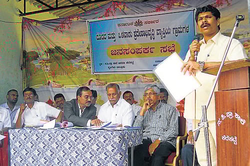 Taluk Panchayat Member Arun Kumar speaks at a public contact programme at Kerekatte in Sringeri on Wednesday. District-in-Charge Minister Abhayachandra Jain, MP Jayaprakash Hegde, DC Shekarappa and others look on.