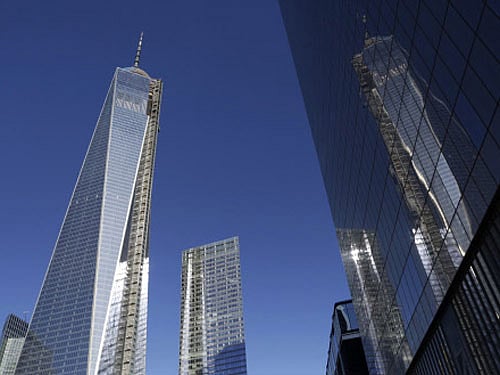 One World Trade Center, left, is reflected in the glass facade of its neighbor, 4 World Trade Center, Wednesday, Nov. 13, 2013 in New York. A ribbon-cutting was held Wednesday to open the 978-foot (298-meter) 4 World Trade Center. AP Photo