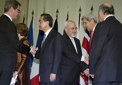 From left, Germany's Foreign Minister Guido Westerwelle, Chinese Foreign Minister Wang Yi, Iranian Foreign Minister Mohammad Javad Zarif, U.S. Secretary of State John Kerry, and French Foreign Minister Laurent Fabius greet each other and shake hands at the United Nations Palais, Sunday, Nov. 24, 2013, in Geneva, Switzerland, at the Iran nuclear talks. A deal has been reached between six world powers and Iran that calls on Tehran to limit its nuclear activities in return for sanctions relief, the French and Iranian foreign ministers said early Sunday. AP photo