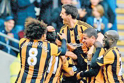 party starter: Hull City's Jake Livermore is mobbed by his team-mates after scoring the opener against Liverpool on Sunday. REUTERS