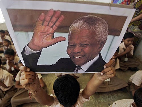 A boy holds a portrait of former South African president Nelson Mandela on hearing of his death, at a school in Ahmadabad, India, Friday, Dec. 6, 2013. Mandela, South Africa's first black president, died Thursday in Johannesburg, South Africa after a long illness. He was 95. AP Photo