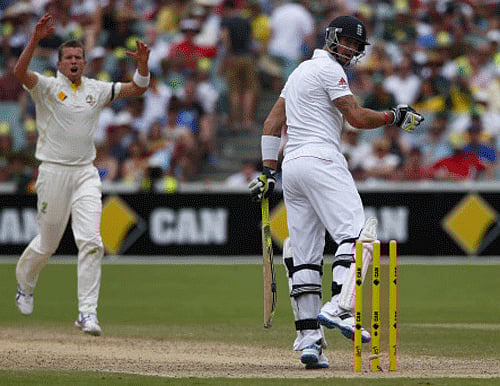 England's Kevin Pietersen looks at the stumps after he was bowled out by Australia's Peter Siddle (L) during the fourth day of the second Ashes test cricket match at the Adelaide Oval December 8, 2013. REUTERS