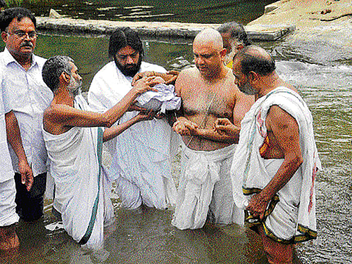 Last rites: Chaduranga Kanthraja Urs, nephew of the late scion of the Mysore royal family Srikantadatta Narasimharaja Wadiyar, performs rituals before immersing the ashes of his  uncle in River Cauvery at Paschimavahini, in Srirangapatna on Thursday. DH Photo