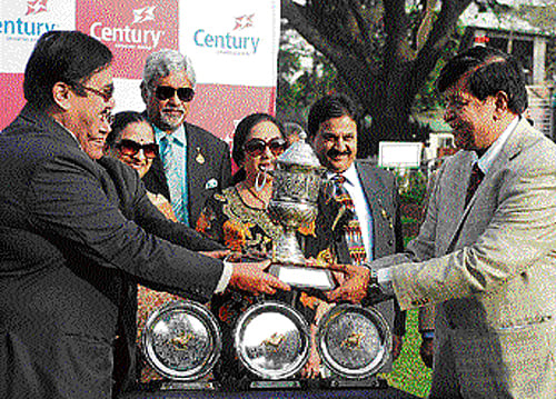 proud moment AK Jaiswal (right), owner of Turf Striker, receives the Bangalore 2000 Guineas trophy from Satish Pai (left) at the Bangalore Turf Club on Saturday. dh photo
