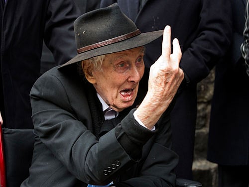 File photograph shows Great Train Robber Ronnie Biggs gesturing as he arrives for the funeral of Bruce Reynolds, at the church of St Bartholomew the Great in London March 20, 2013. Biggs, one of Britain's most notorious criminals known for his role in the Great Train Robbery of 1963, died on December 18, 2013 at the age of 84, his spokeswoman said. REUTERS