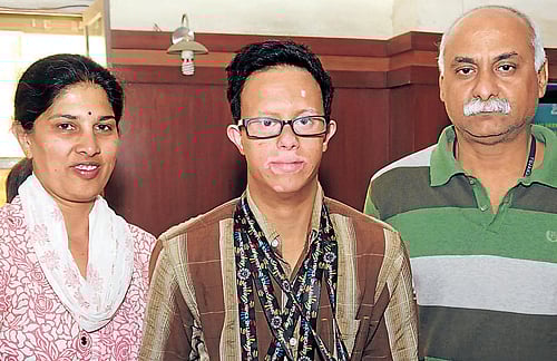 Anand (centre) poses with the medals along with his parents Chaya and Sudesh. DH Photo