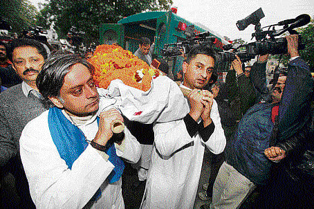 Union minister Shashi Tharoor carries the mortal remains of his wife Sunanda Pushkar during her cremation procession at Lodhi Road crematorium in New Delhi on Saturday. DH photo