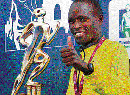 On cloud: nine Evans Ruto celebrates with his spoils after winning the men's full marathon in Mumbai on Sunday. PTI