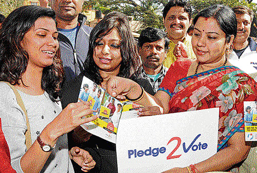 Actor Tara hands out voter awareness pamphlets to people at a campaign in the City on Sunday. dh Photo