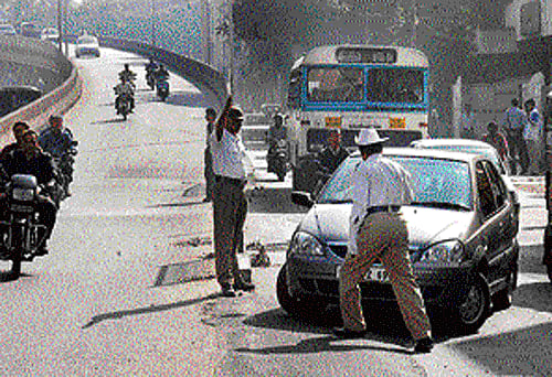 Unnecessary: Though it is outside their jurisdiction, the traffic police continue to stop  vehicles with non-Karnataka registration numbers.