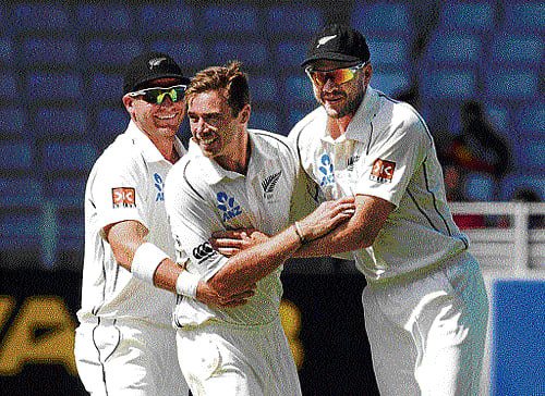 well done mate: New Zealand pacer Tim Southee (centre) celebrates the wicket of India's Rohit Sharma with team-mates Corey Anderson (left) and Peter Fulton on the fourth day of the first Test at Auckland on Sunday. reuters