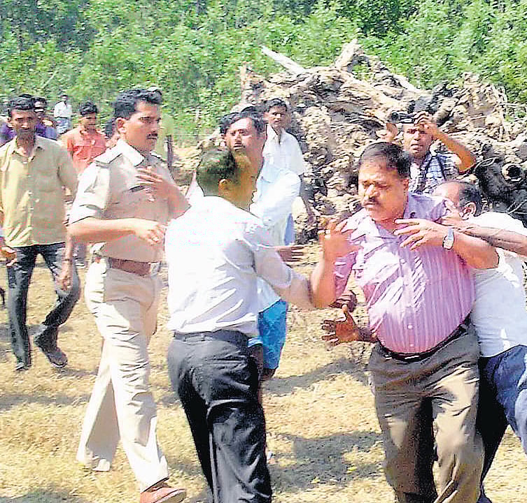 Angry villagers attack Range Forest Officer Devaraj at Kallare village in Alur taluk of Hassan district on Tuesday after an elephant trampled a farmer to death. KPN