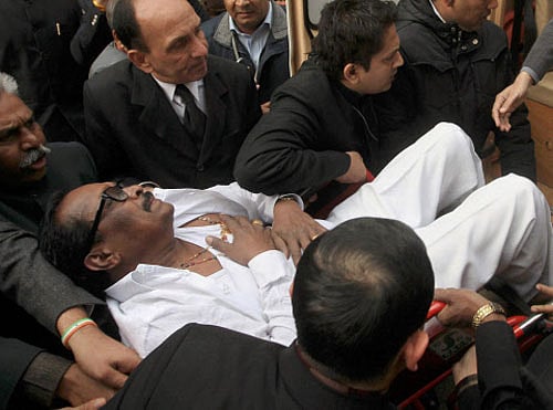 People carry Member of  Parliament K Narayana Rao to a hospital during clashes between members in the Lok Sabha in New Delhi on Thursday. AP
