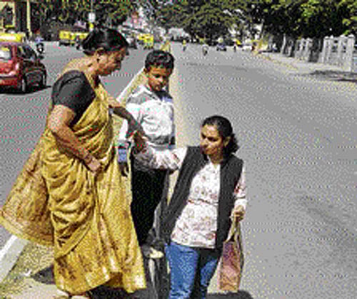 RISKY CROSSING:  Senior citizens find it extremely tough to cross the roads.  Traffic constables are rarely  seen helping them get to the  other side safely.