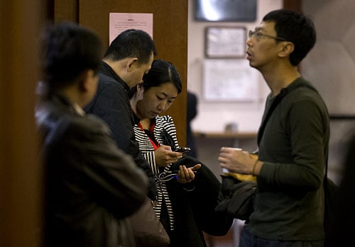 Chinese relatives of passengers aboard a missing Malaysia Airlines plane stand inside a hotel room after attending a briefing by Malaysia Airlines in Beijing, China Sunday, March 16, 2014. Attention focused Sunday on the pilots of the missing Malaysia Airlines flight after the country's leader announced findings so far that suggest someone with intimate knowledge of the Boeing 777's cockpit seized control of the plane and sent it off-course. (AP Photo)