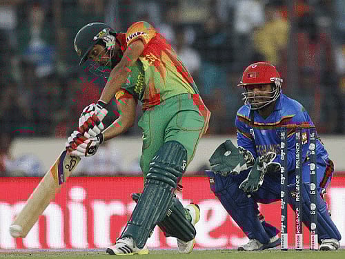 Bangladesh's Anamul Haque plays a ball as Afghanistan's wicketkeeper Mohammad Shahzad (R) watches during their ICC Twenty20 World Cup match at the Sher-E-Bangla National Cricket Stadium in Dhaka. Reuters