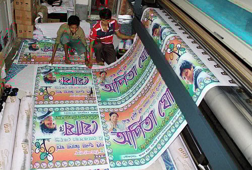 Workers producing flex prints of Trinamool Congress (TMC) posters for the upcoming Lok Sabha election at Balurghat in South Dinajpur district of West Bengal on Saturday. PTI Photo