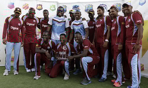 The West Indies cricket team poses with the trophy after beating England 2-1, in the series of three T20 International cricket matches at the Kensington Oval in Bridgetown, AP