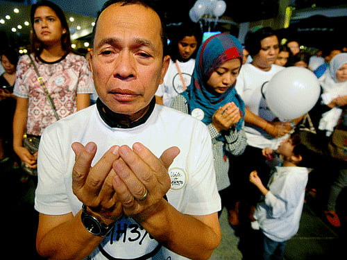 A Malaysian Muslim man prays during an interfaith event for the missing Malaysia Airlines flight MH370 at a shopping mall in Petaling Jaya outside Kuala Lumpur, Malaysia. Australia has sent aircraft to investigate two objects spotted by satellite floating in the southern Indian Ocean that could be debris from a Malaysian jetliner missing with 239 people on board, Prime Minister Tony Abbott said on Thursday. AP photo