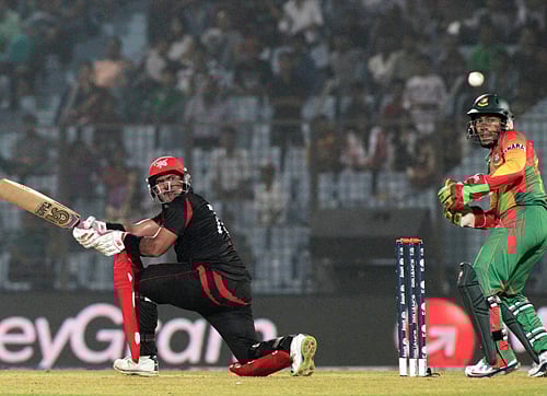 Hong Kong's Munir Dar, left, plays a shot as Bangladesh's captain Mushfiqur Rahim watches during their ICC Twenty20 Cricket World Cup match in Chittagong, Bangladesh, Thursday, March 20, 2014. AP