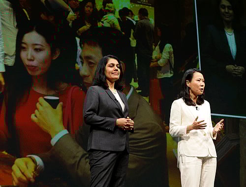 Avani Davda, left, chief executive officer, of Starbucks Tata Limited, the joint-venture company opening Starbucks stores in India, and Belinda Wong, right, president of Starbucks China, stand in front of a photo of an overseas store as they speak Wednesday, March 19, 2014, at the company's annual shareholders meeting in Seattle. With 40 stores in 17 months of its operations, India is the fastest growing market in the history of the Seattle-based iconic American coffee chain Starbucks, according to a company statement. (AP Photo)