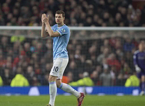 A clinical double from Edin Dzeko helped Manchester City move to second in the Premier League with a 3-0 win at Manchester United on Tuesday while Arsenal's title hopes all but evaporated in a 2-2 draw with Swansea City, AP photo