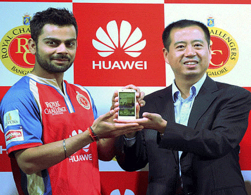 Cai Liqun, CEO, Huawei India, giving Huaei Ascend P6 to Virat Kohli , Captain, Royal Challengers Bangalore during a function in Mumbai on Sunday. PTI Photo