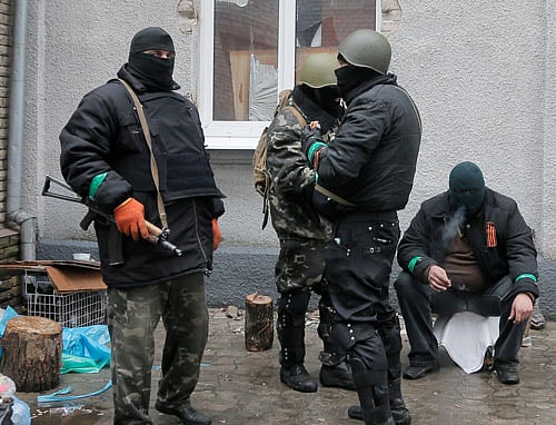 Pro-Russian gunman stand guard at a seized police station in the eastern Ukrainian town of Slovyansk on Sunday, April 13, 2014. Ukrainian special forces exchanged gunfire with a pro-Russia militia in an eastern city Sunday, with at least one security officer killed and five others wounded. It was the first reported gunbattle in eastern Ukraine, where armed pro-Russia men have seized a number of government buildings in recent days. AP