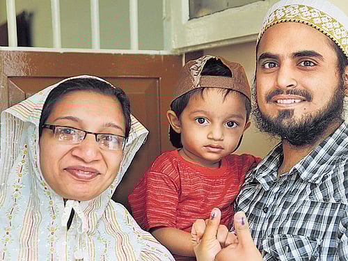 A family poses for photographers after casting their vote at  the RV Teachers' College booth at Jayanagar. DH Photo