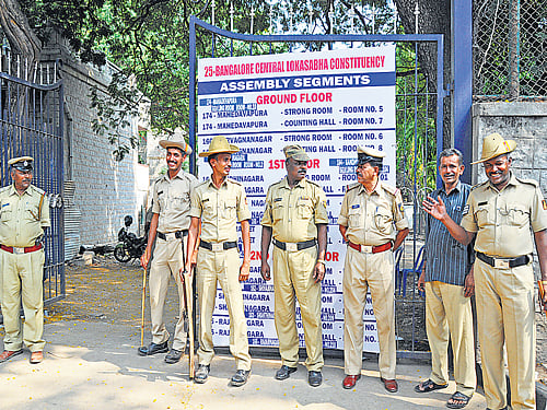 Police personnel on Friday guard the  Government RC College of Commerce and Management in the City where the electronic voting machines are stored. DH Photo
