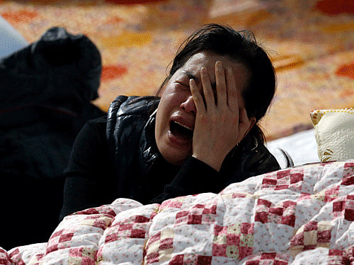 A family member of a missing passenger onboard the Sewol ferry which capsized on Wednesday, cries as she checks the newly announced list of the dead, at a gym in Jindo. Reuters photo