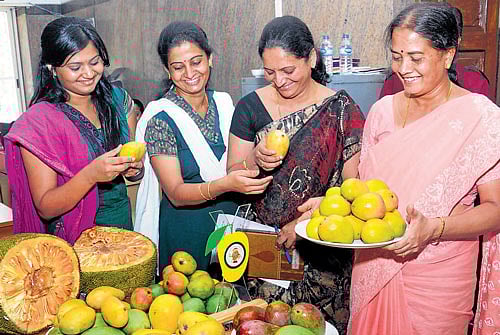Women take a look at mangoes and jackfruits on display at a press conference in Bangalore on Wednesday. DH photo