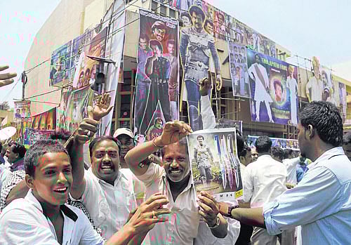 Rajini fans hold his poster in front of Nataraj theatre during the release of 'Kochadiiyaan' in Bangalore on Friday. DH Photo