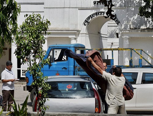Police officials cover the Indica car at Tuglak Road police station which hit Rural Development Minister Gopinath Munde's car leading to his death in New Delhi on Tuesday. PTI Photo