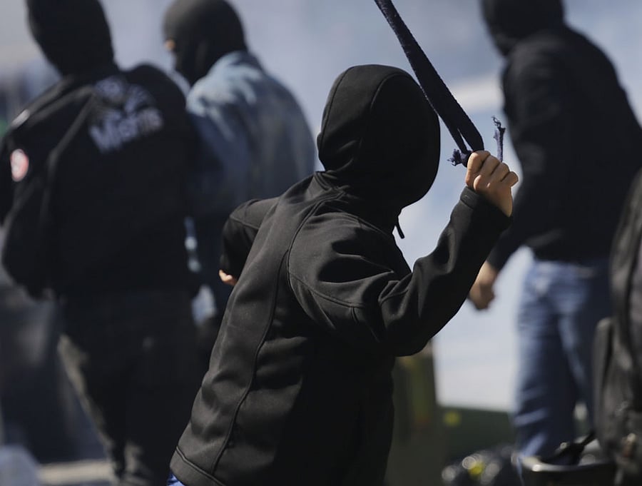 A protester winds up to sling a stone at police after clashes erupted in Sao Paulo, Brazil, Thursday, June 12, 2014. Police clashed with anti-World-Cup protesters who were trying to block a road part of the main highway leading to the stadium that hosts the opening match to the tournament. in Sao Paulo, Brazil, Thursday, June 12, 2014. (AP Photo