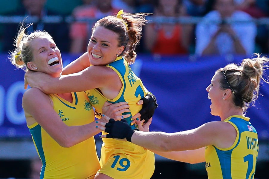 Australia's Georgie Parker, center, and Australia's Kellie White, right, hug Jodie Kenny, left, who scored the decisive goal in the shootout during the Field Hockey World Cup semifinal match women between the U.S. and Australia in The Hague, Netherlands, Thursday, June 12, 2014. The match ended in a 2-2 draw, Australia won the shootout 3-1 and continues to the final. (AP Photo