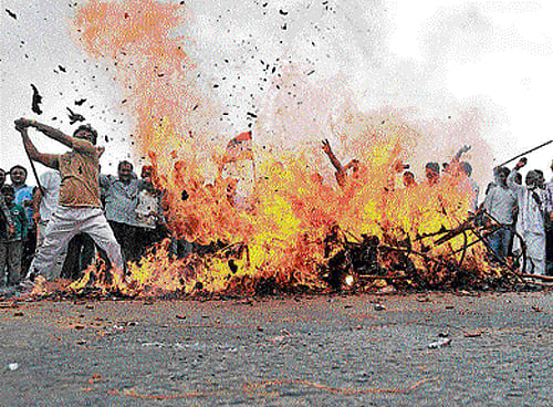 Congress party workers burn an effigy of Union Power Minister Piyush Goyal as they protest against the recurring power outages affecting the city, in New Delhi on Thursday. DH PHOTO/chaman Gautam