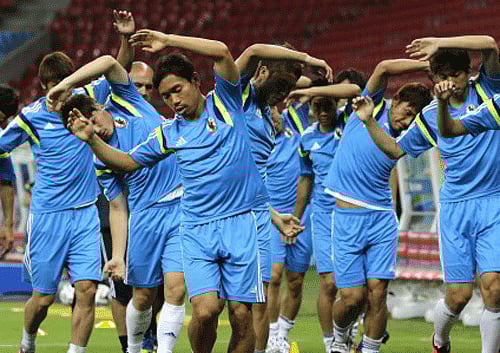 Japan's Yuto Nagatomo, center, with teammates warm up during a training session of Japan at the Arena Pernambuco in Recife, Brazil. AP photo