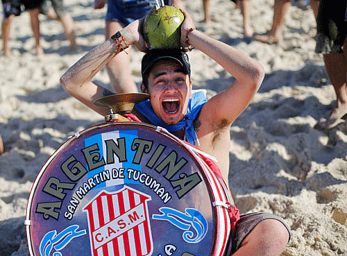 An Argentina soccer fan with a drum and coconut gathers with other fans on Copacabana beach ahead of the final World Cup match between Argentina and Germany in Rio de Janeiro, Brazil, Sunday, July 13, 2014. (AP Photo)